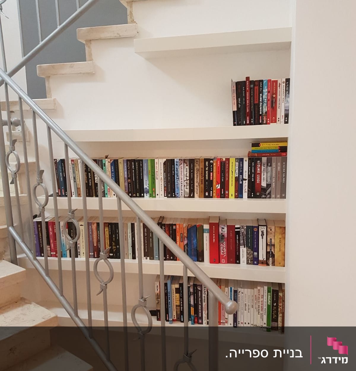 מדפי עץ מתחת למדרגות עם ספרים